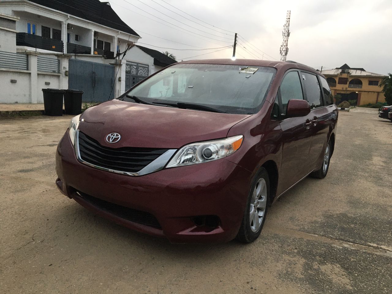 White 2018 Toyota Corolla sedan parked on a busy Lagos street with palm trees and buildings in the background
